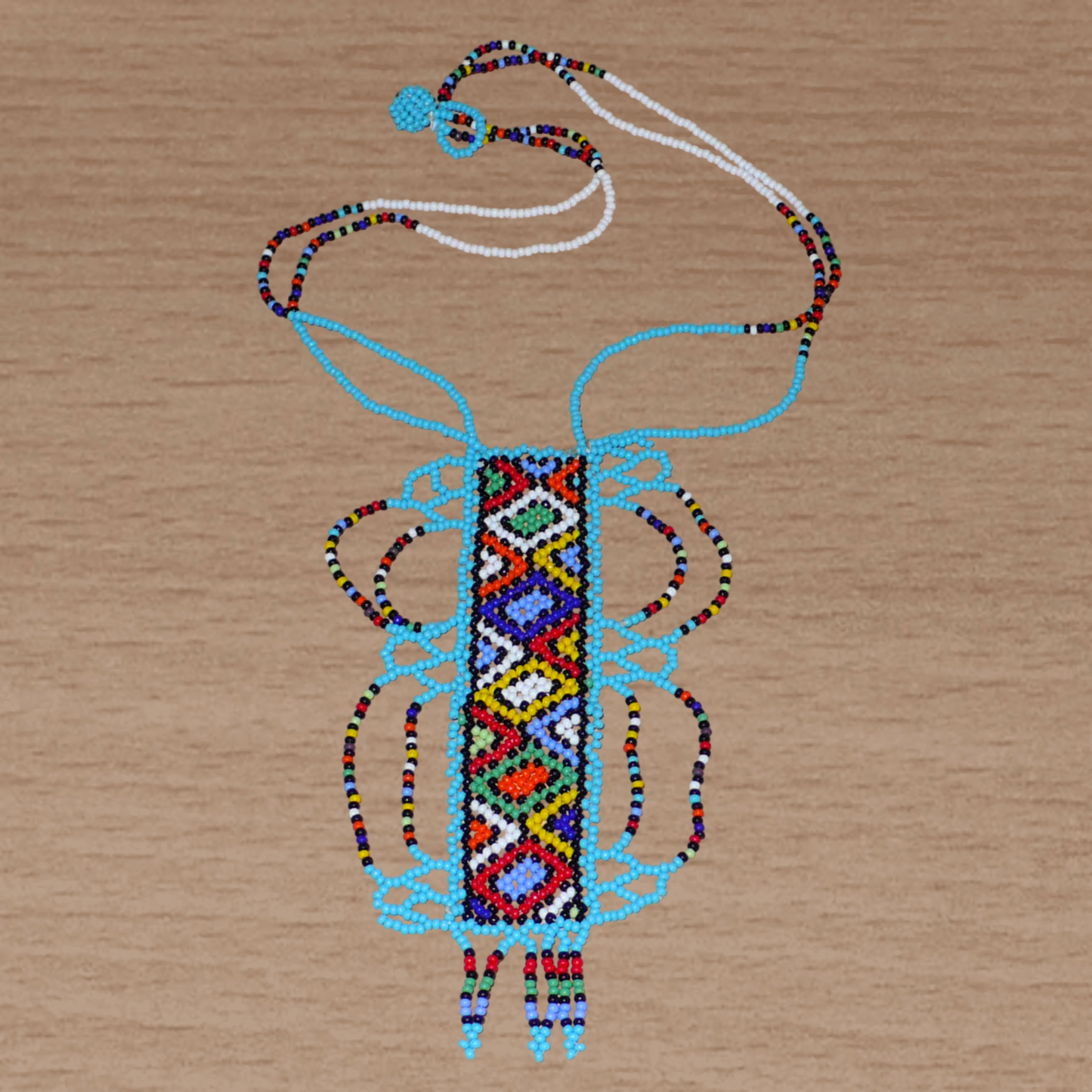 Collier sud-africain traditionnel bleu et multicolore agrémenté d'un long et large pendentif décoré de motifs ethniques zoulous.