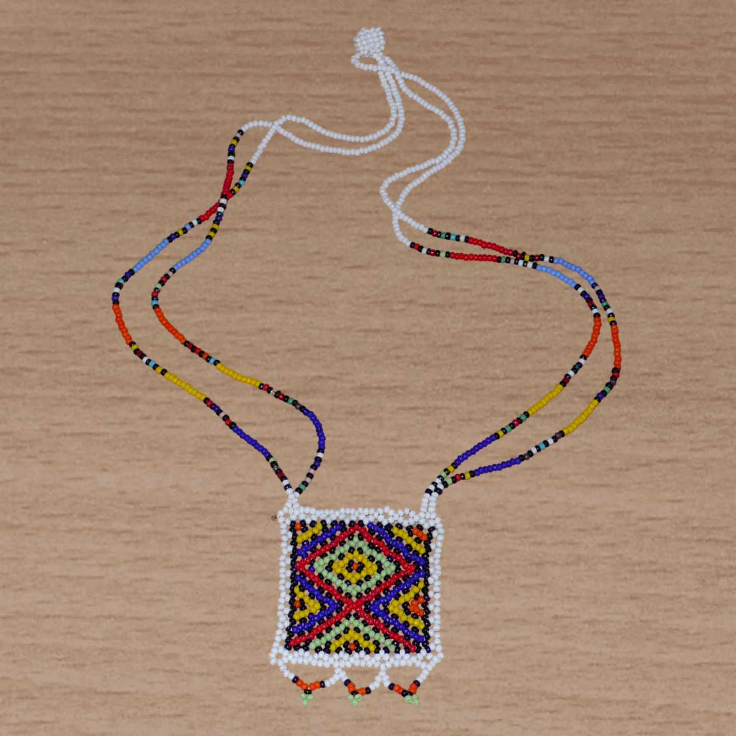 Collier sud-africain "Zulu Love Letter" avec pendentif à motifs ethniques zoulous en perles de rocaille blanches et multicolores.