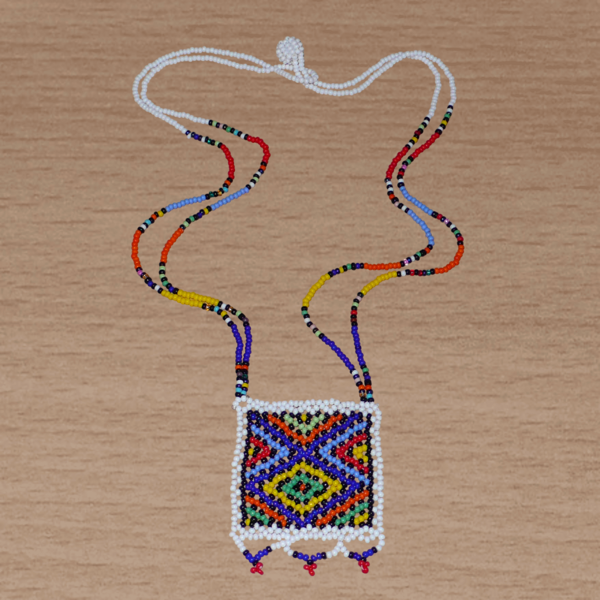 Collier sud-africain traditionnel "Zulu Love Letter" avec pendentif décoré de motifs ethniques zoulous composé d'un tissage de perles de rocaille blanches et multicolores.