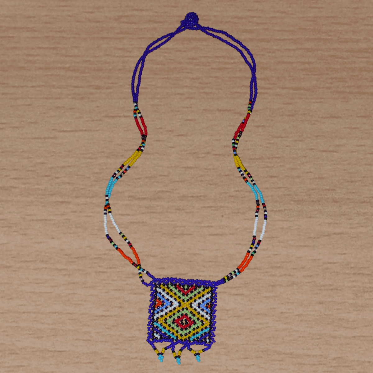Collier sud-africain traditionnel "Zulu Love Letter" avec pendentif composé de perles de rocaille leu foncé et multicolores.