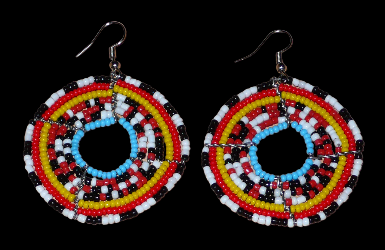 Boucles d'oreilles ethniques composées d'un mélange de perles de rocaille principalement rouges, noires, blanches et bleues montées en cercles. Elles mesurent 6,5 cm de long et 5 cm de large et se portent sur des oreilles percées.