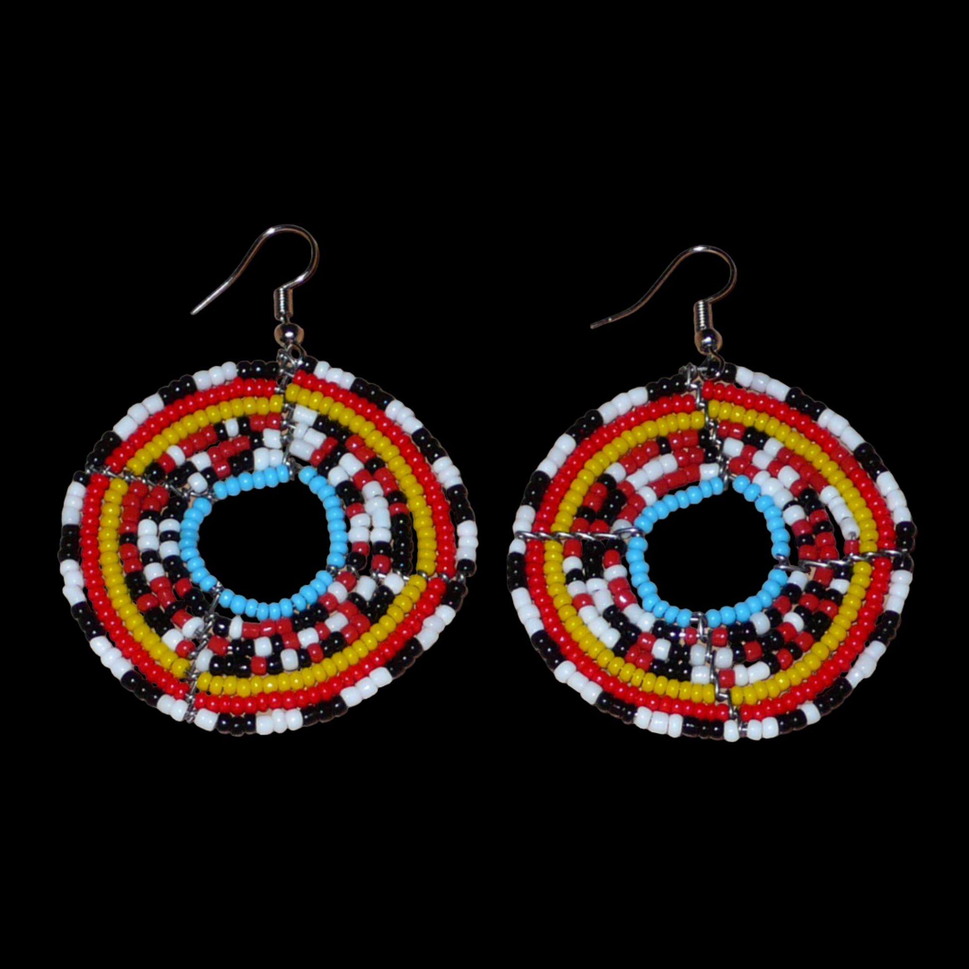 Boucles d'oreilles ethniques rondes faites d'un mélange de perles de rocaille rouges, noires, blanches, jaunes et bleues. Elles mesurent 6,5 cm de long et 5 cm de large et se portent sur des oreilles percées.
