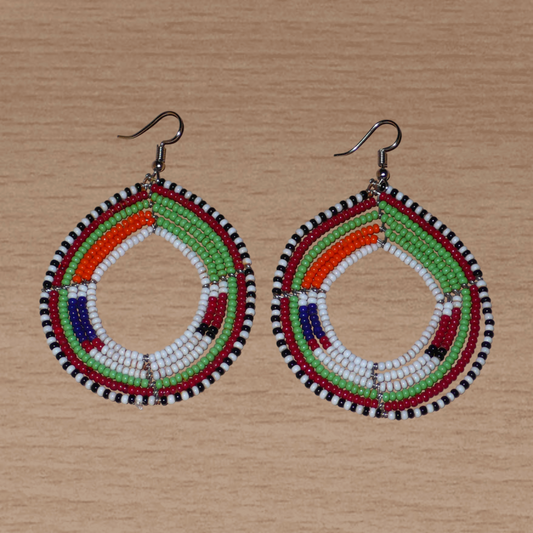 Longues boucles d'oreilles ethniques Massai faites de perles de rocaille fixées sur six rangées de fils de fer montés en cercles. Elles mesurent 8 cm de long et 5,5 cm de larges et se portent avec des crochets en acier inoxydable sur des oreilles percées.