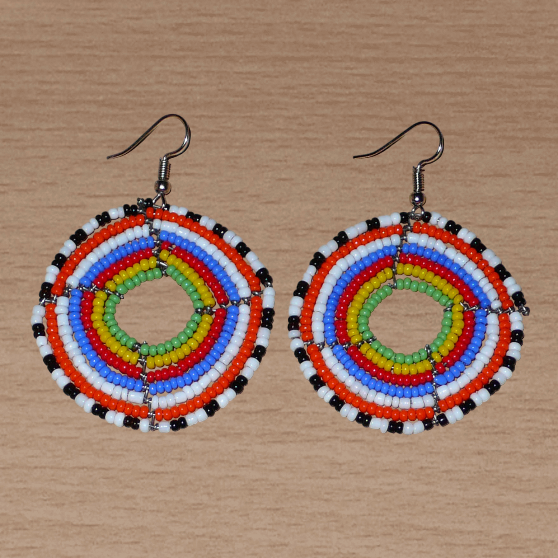 Boucles d'oreilles ethniques rondes composées de perles de rocaille multicolores ; elles mesurent 6,5 cm de long et 4,5 cm de large.