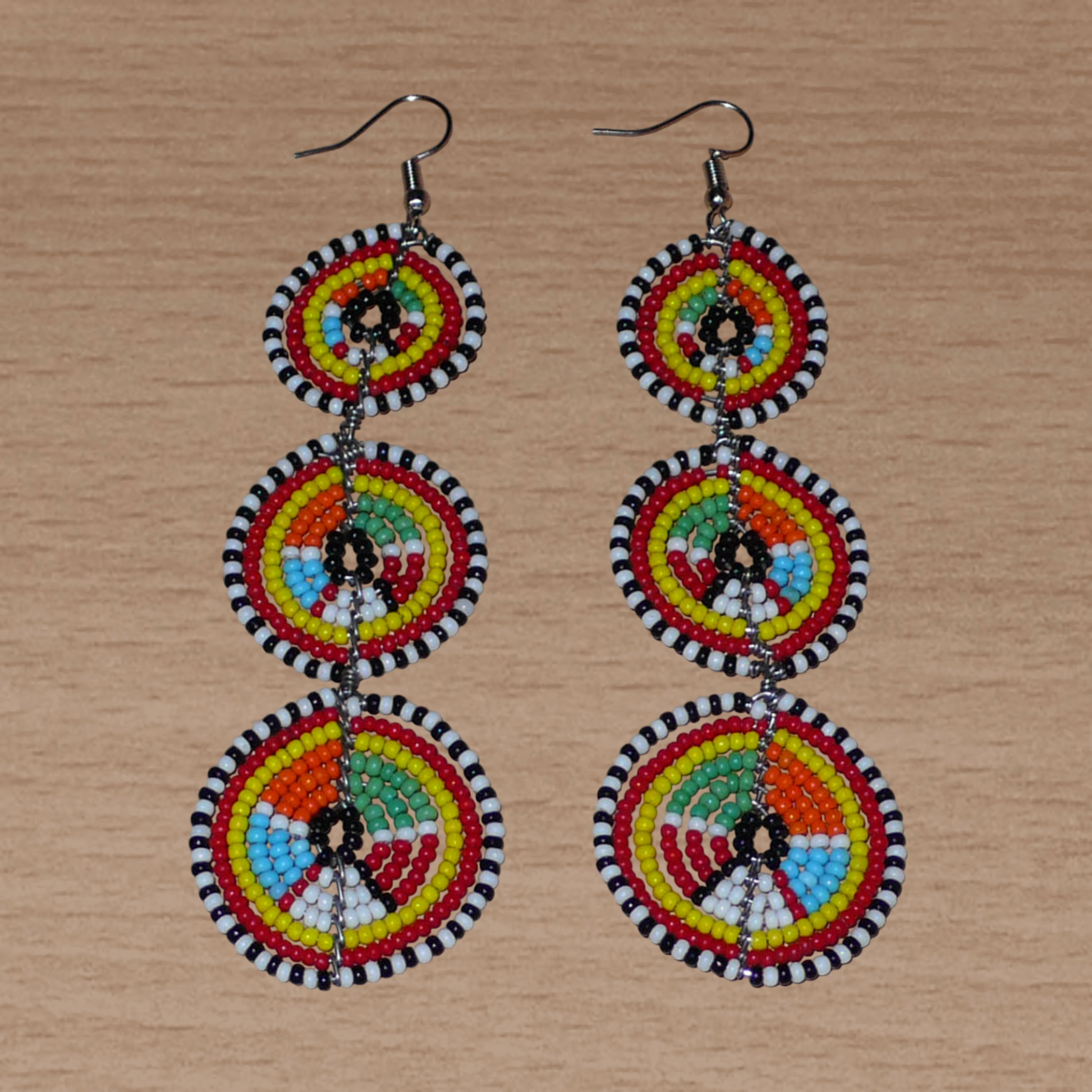 Longues boucles d'oreilles africaines Massai composées de perles multicolores montées en trois cercles superposées. Elles mesurent 11 cm de long et 3.5 cm de large.