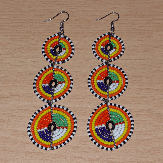 Longues boucles d'oreilles ethniques afro chic composées de perles de rocaille multicolores montées en trois cercles superposés. Elles mesurent 10,5 cm de long et 3 cm de large. 