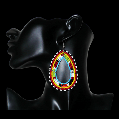 Longues boucles d'oreilles africaines à motifs ethniques Massai faites de perles de rocaille multicolores enfilées sur six rangées de fils de fer montés en forme de gouttes. Elles mesurent 8,5 cm de long et 5 cm de large, et se portent sur des oreilles percées.
