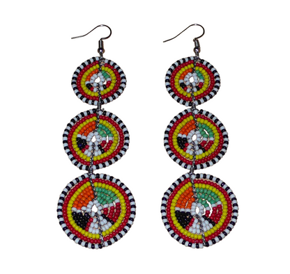 Longues boucles d'oreilles africaines composées de trois cercles superposés en perles de rocaille multicolores. Elles mesurent 11 cm de long et 3 cm de large et se portent avec des crochets en acier inoxydable sur des oreilles percées.