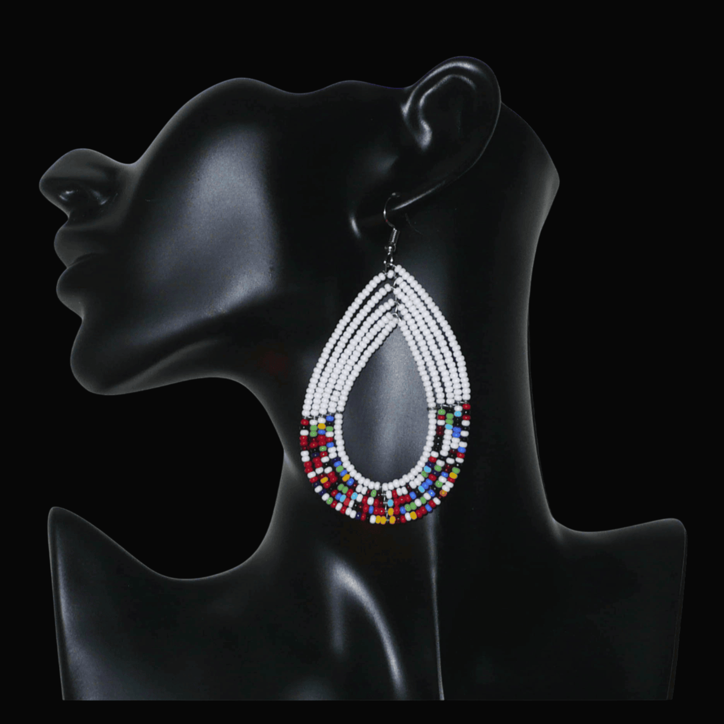 Longues boucles d'oreilles ethniques multi-rangs faites de perles de rocaille blanches et multicolores montées en forme de gouttes. Elles mesurent 9 cm de long et 4.5 cm de large, et se portent sur des oreilles percées.