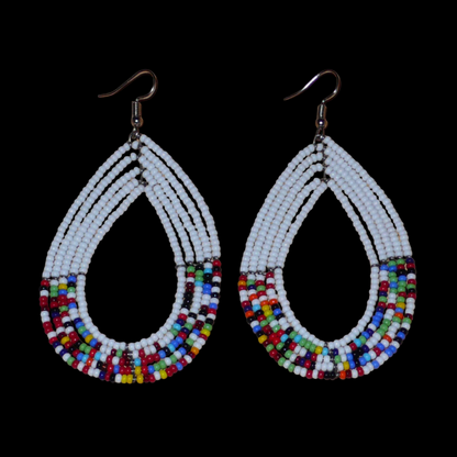 Longues boucles d'oreilles ethniques multi-rangs faites de perles de rocaille blanches et multicolores montées en forme de gouttes. Elles mesurent 9 cm de long et 4.5 cm de large, et se portent sur des oreilles percées.