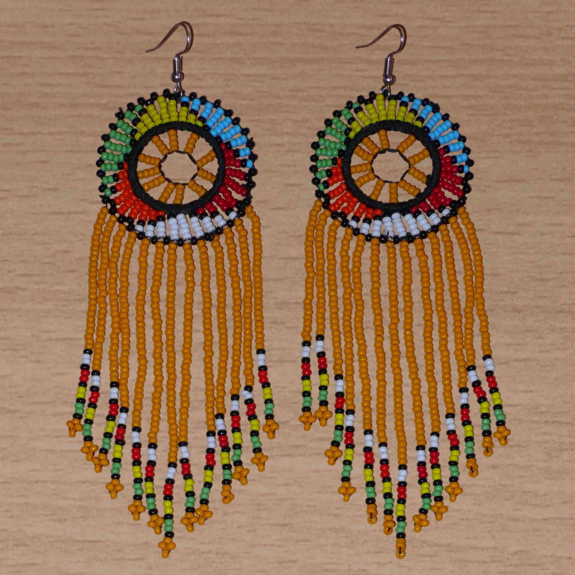 Longues boucles d'oreilles africaines à franges faites de perles orange et multicolores. Elles mesurent 15 cm de long et 4.5 cm de large.