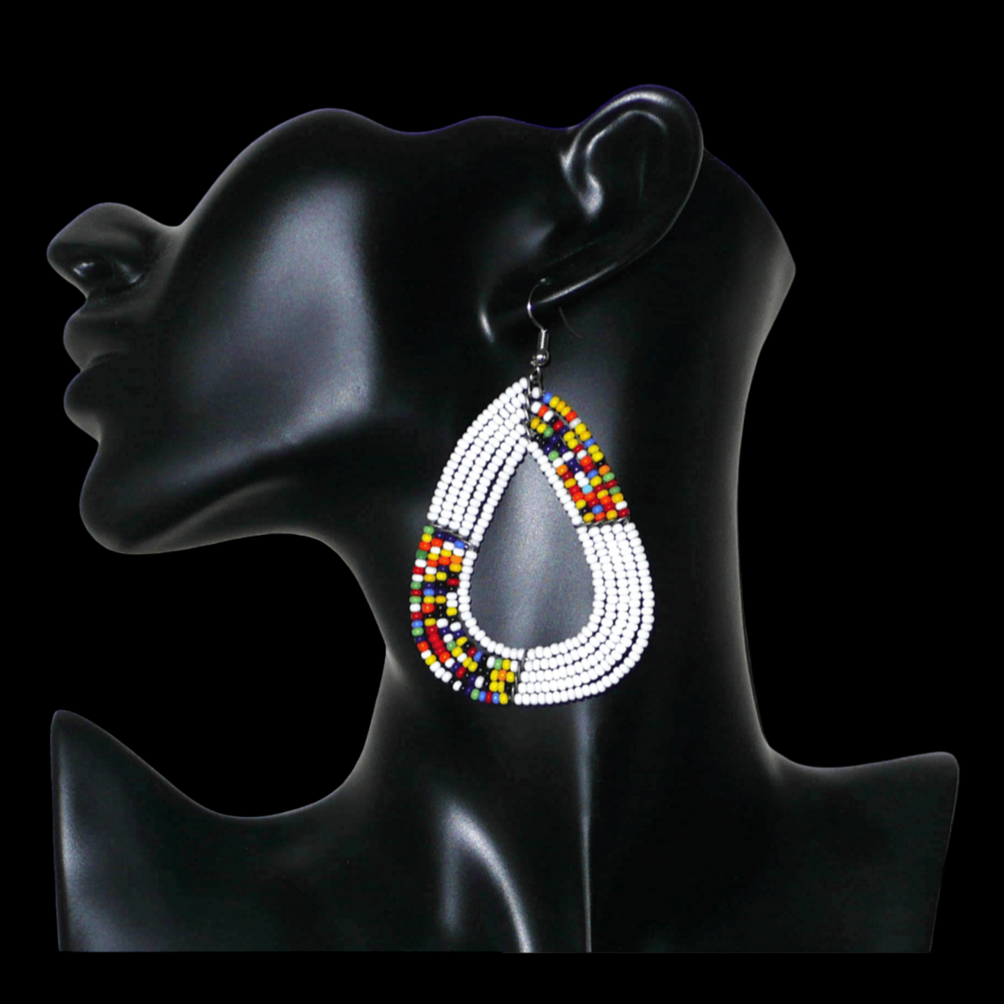 Longues et larges boucles d'oreilles kenyanes composées de perles de rocaille blanches et multicolores glissées sur cinq rangées de fils de fer montés en forme de gouttes légèrement triangulaires. Elles mesurent 8 cm de long et 5 cm de large et se portent avec des crochets en acier inoxydable sur des oreilles percées.