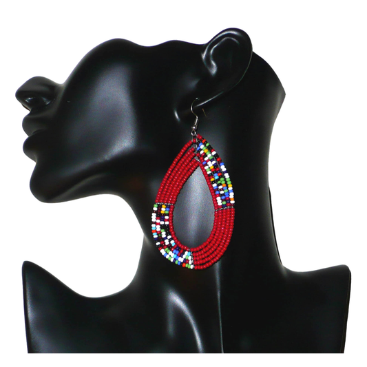 Longues boucles d'oreilles Massai multi-rangs rouges et multicolores en perles de rocaille. Elles mesurent 9 cm de long et 4.5 cm de large et se portent sur des oreilles percées.