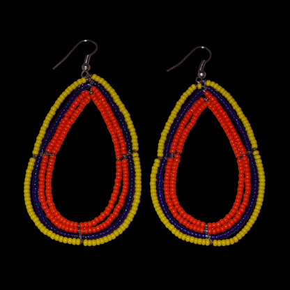 Longues et larges boucles d'oreilles ethniques multi-rangs en perles de rocaille orange, jaunes et bleu marine. Elles mesurent 8.5 cm de long et 4.5 cm de large, et se portent sur des oreilles percées.