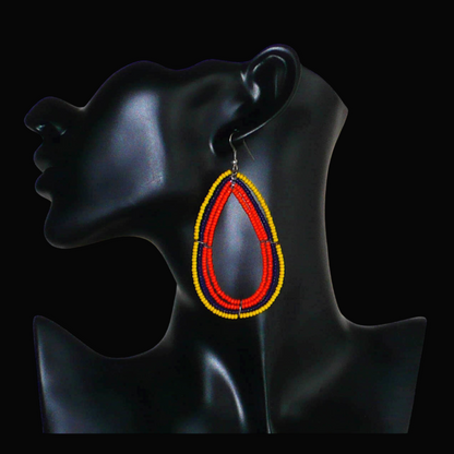 Longues et larges boucles d'oreilles ethniques multi-rangs en perles de rocaille orange, jaunes et bleu marine. Elles mesurent 8.5 cm de long et 4.5 cm de large, et se portent sur des oreilles percées.
