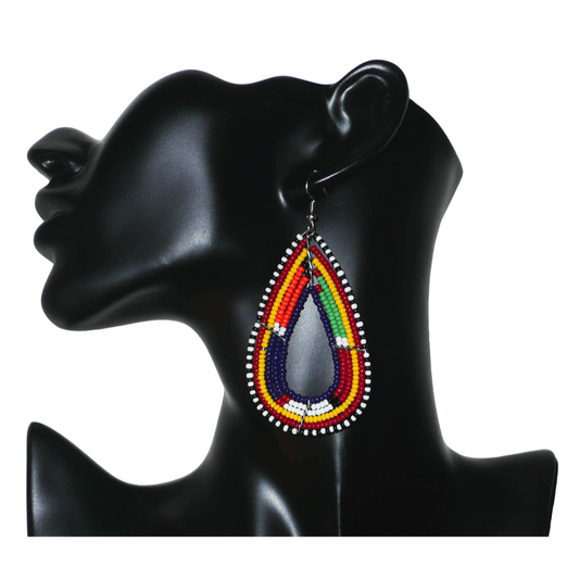 Longues boucles d'oreilles africaines tribales Massai composées de perles bleu foncé et multicolores montées en forme de gouttes. Ces boucles d'oreilles mesure 8,5 cm de long et 4 cm de large ; elles se portent avec des crochets en acier inoxydable sur des oreilles percées. 