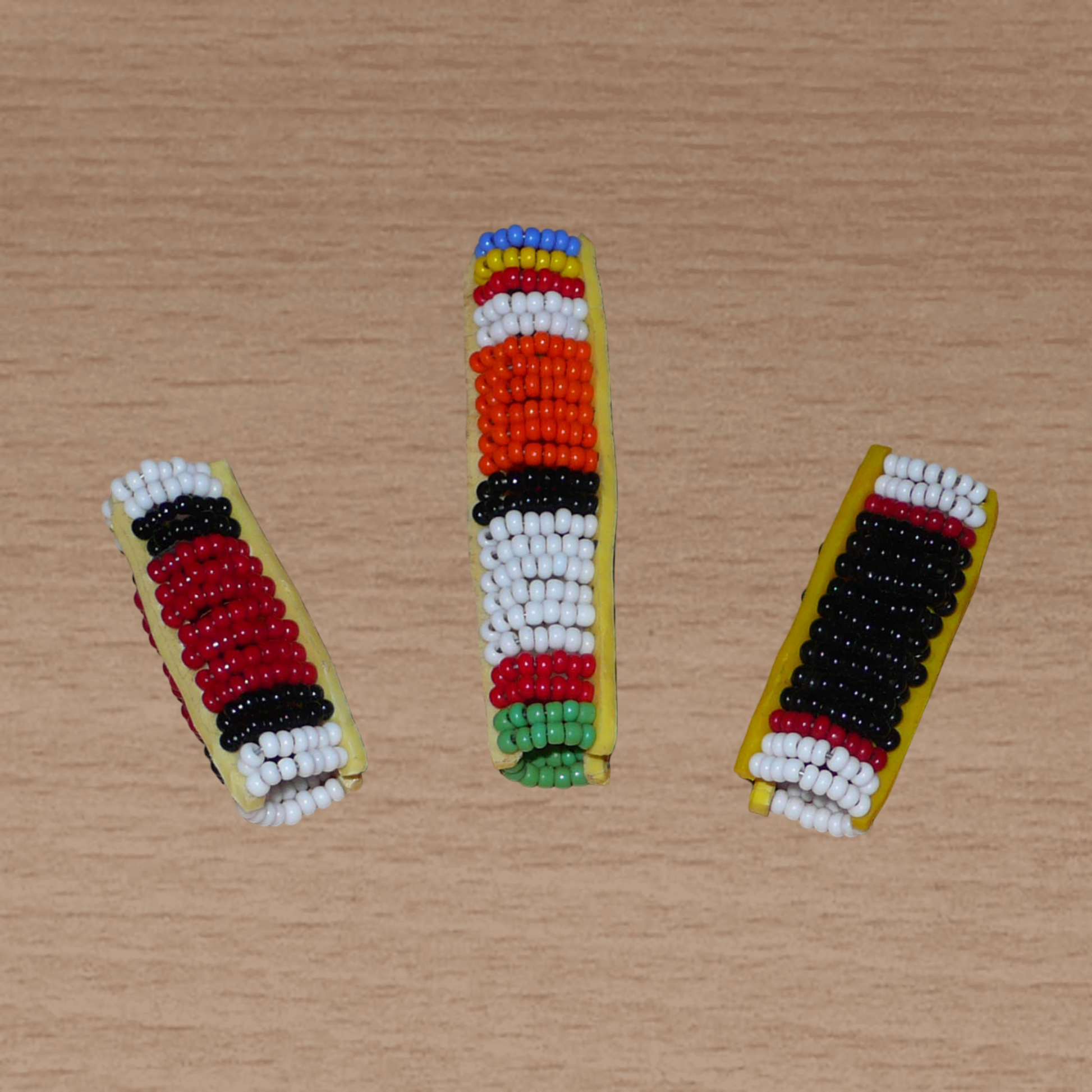Lot de trois bijoux de locs composés de perles de rocaille aux couleurs et motifs ethniques Massai. Ils se portent sur des dreadlocks fin ou de taille moyenne.