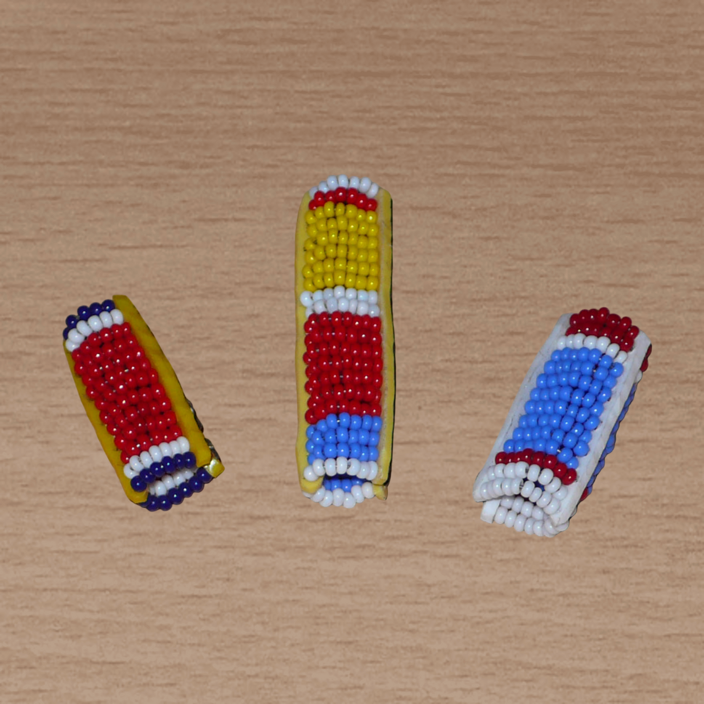 Lot de trois bijoux pour dreadlocks composés de perles de rocaille aux couleurs Massai. Ils se portent sur des locs fins ou de taille moyenne, soit en les faisant glisser, soit en les appliquant par pression.