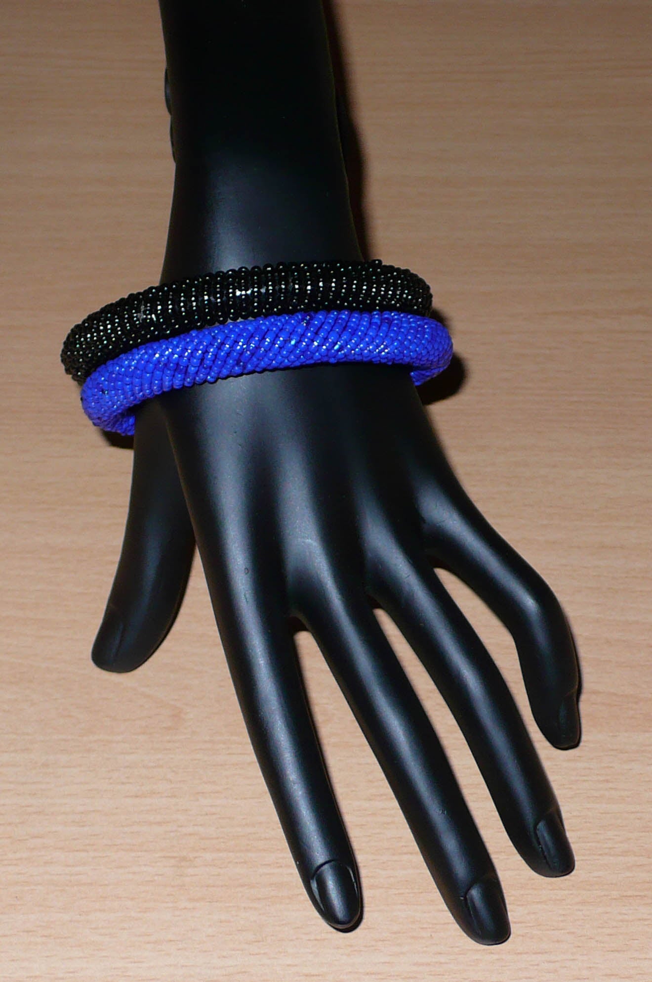 Lot de deux bracelets africains tubulaires de tradition kenyane composés de perles de rocaille noires et bleues.