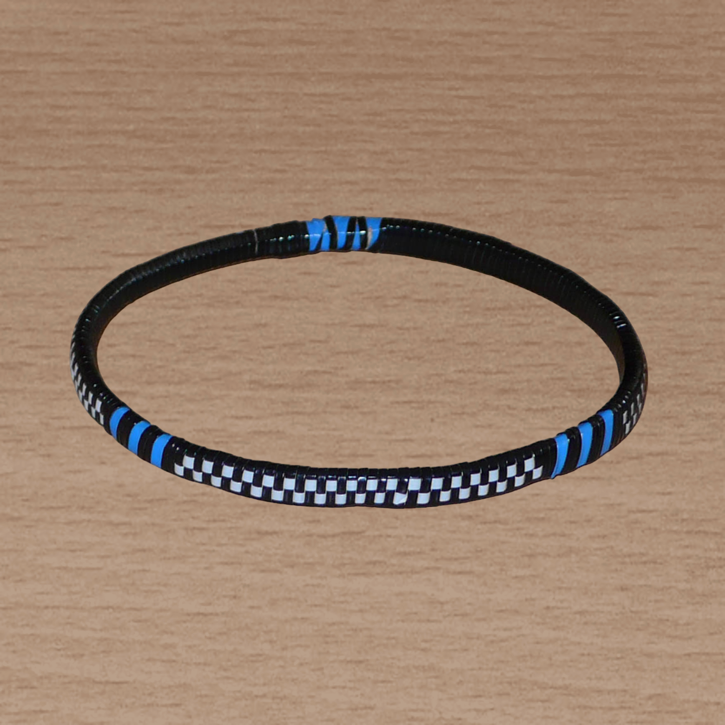 Lot de douze bracelets africains tricolores en plastique recyclé bleu, noir et blanc.