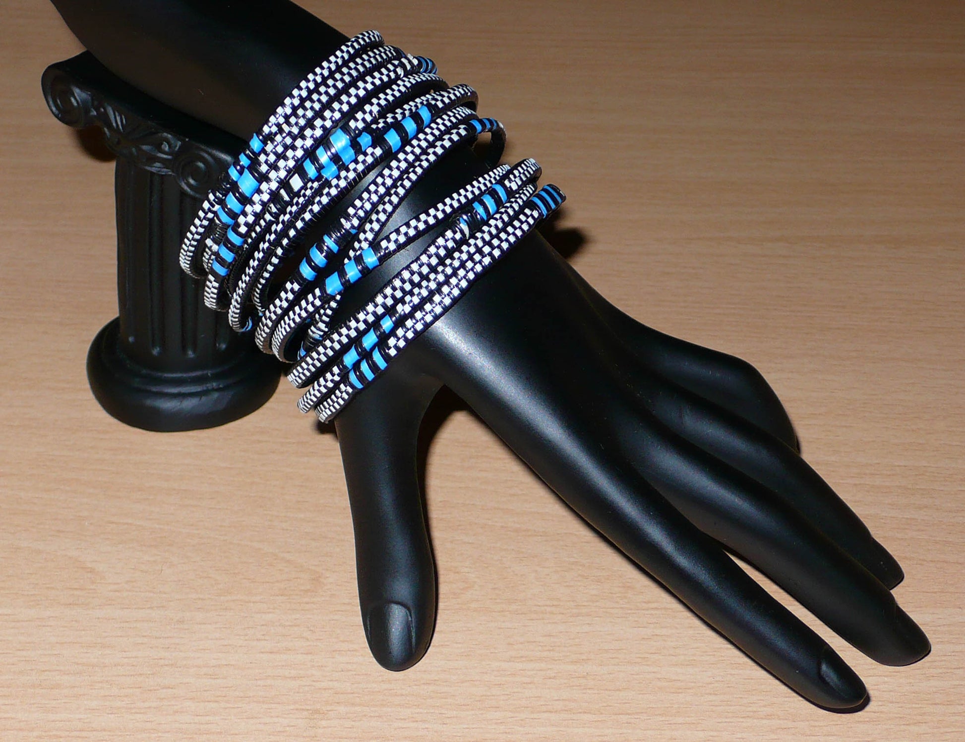 Lot de douze bracelets africains tricolores en plastique recyclé bleu, noir et blanc.