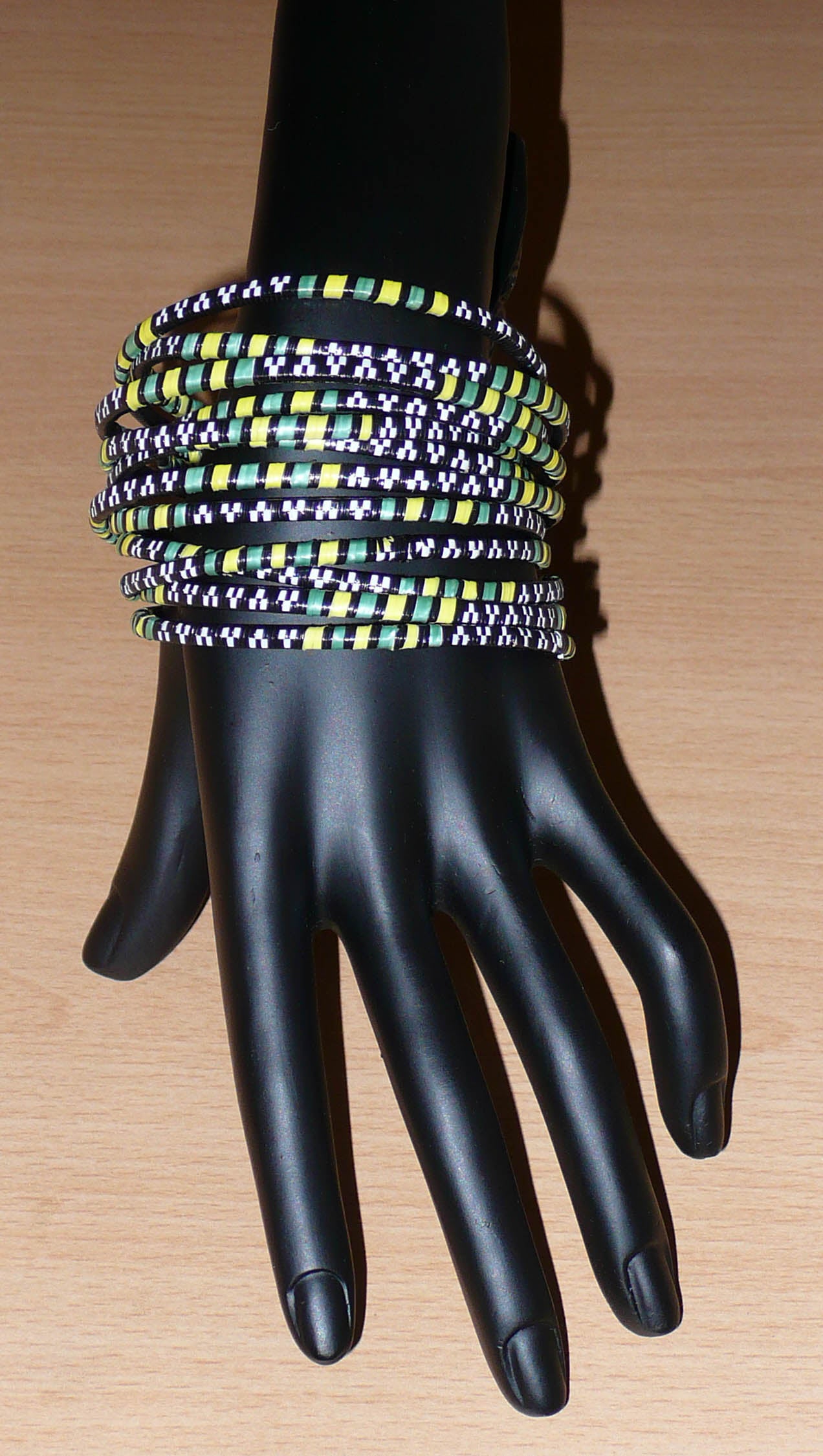 Lot de 12 bracelets africains fabriqués au Burkina Faso dans une démarche eco-responsable avec du plastique recyclé kaki, jaune, noir et blanc.