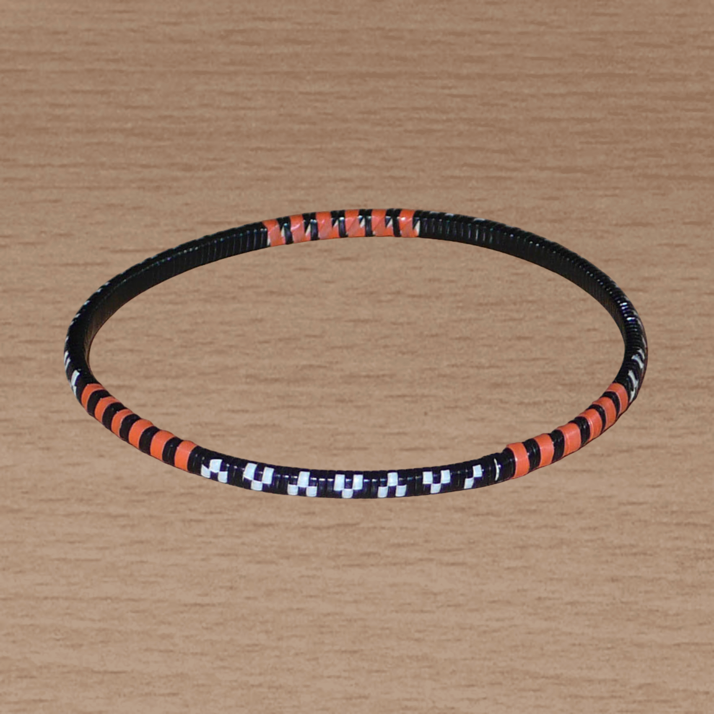 Lot de douze bracelets africains tricolores, fabriqués au Burkina Faso dans une démarche eco-responsable, composés de plastique recyclé orange, noir et blanc.