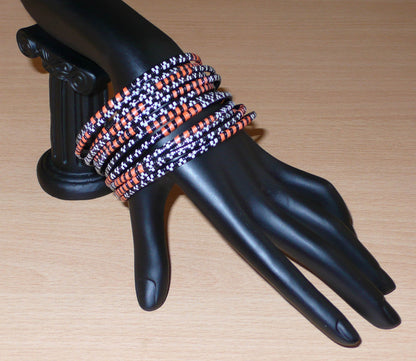 Lot de douze bracelets africains tricolores, fabriqués au Burkina Faso dans une démarche eco-responsable, composés de plastique recyclé orange, noir et blanc.
