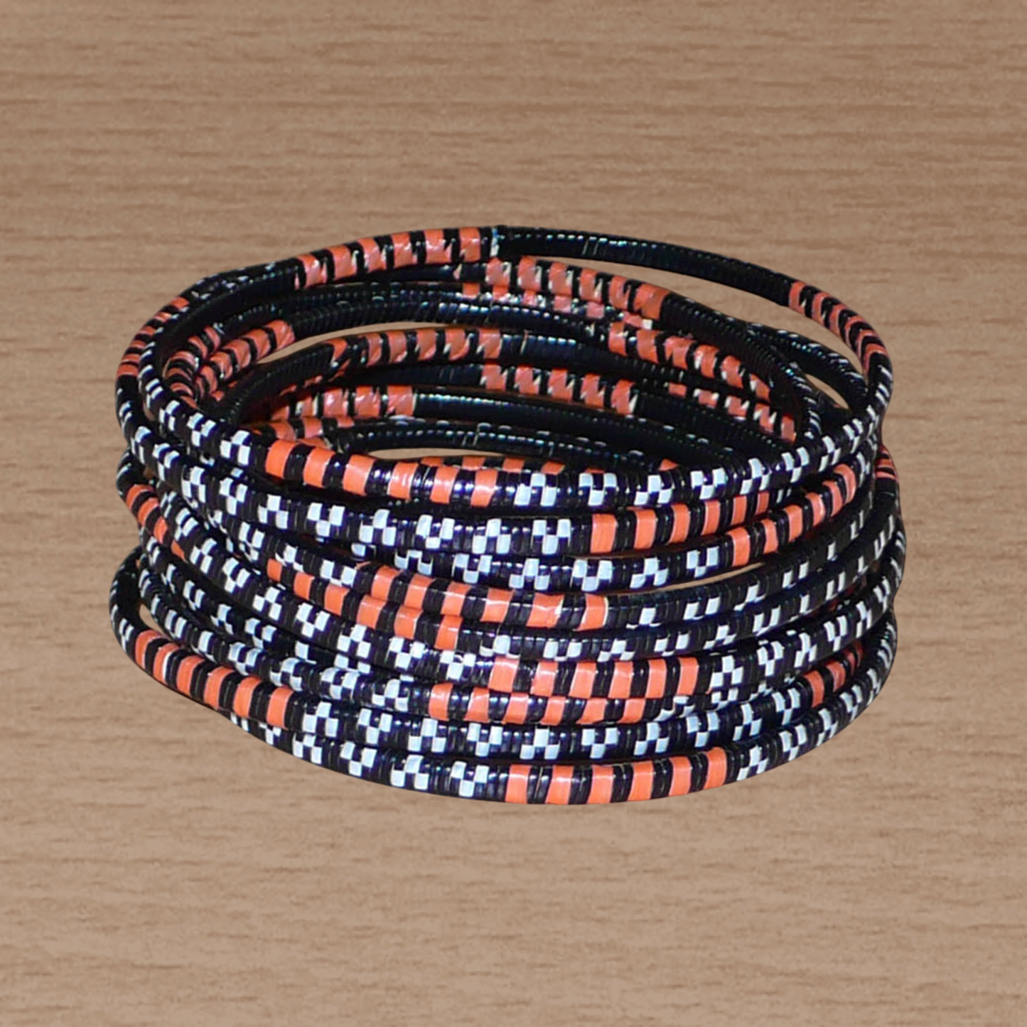 Lot de douze bracelets africains tricolores, fabriqués au Burkina Faso dans une démarche eco-responsable, composés de plastique recyclé orange, noir et blanc.