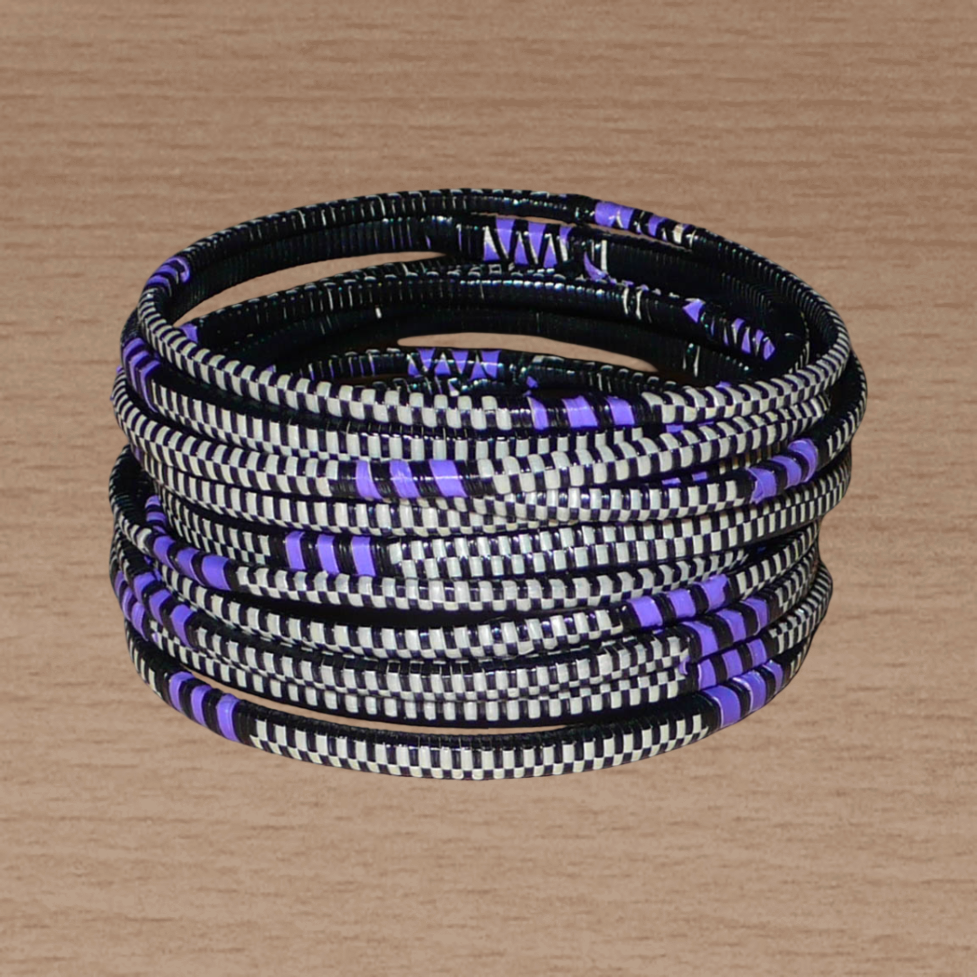 Ensemble de 12 bracelets africains tricolores fabriqués au Mali dans une approche éco-responsable : très fins, ils sont composés de fines bandes de plastique recyclé violet, noir et blanc. Ces bracelets, à empiler sur vos poignets, ont une circonférence de 19.5 cm, un diamètre de 6.3 cm et une épaisseur de 0.4 cm.