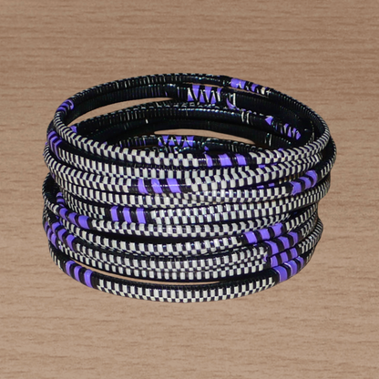 Ensemble de 12 bracelets africains tricolores fabriqués au Mali dans une approche éco-responsable : très fins, ils sont composés de fines bandes de plastique recyclé violet, noir et blanc. Ces bracelets, à empiler sur vos poignets, ont une circonférence de 19.5 cm, un diamètre de 6.3 cm et une épaisseur de 0.4 cm.