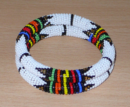 Lot de deux bracelets africains à motifs zoulous traditionnels, composés de perles de rocaille blanches et multicolores.