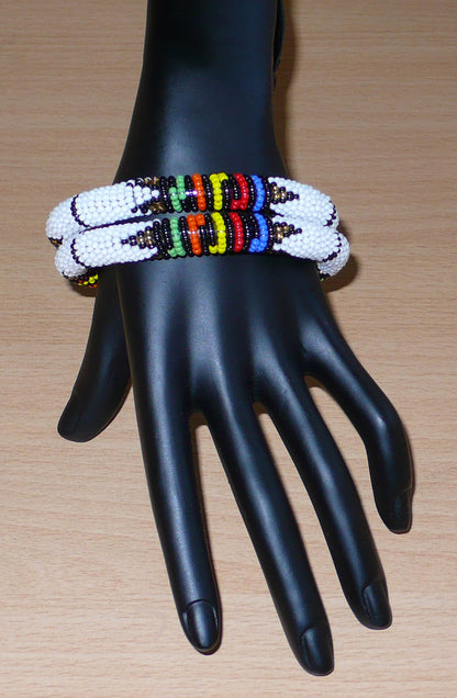 Lot de deux bracelets africains à motifs zoulous traditionnels, composés de perles de rocaille blanches et multicolores.