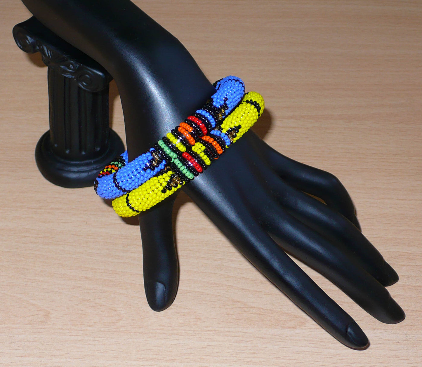 Lot de deux bracelets tubulaires de tradition sud-africaine zouloue, composés de perles de rocaille bleues pour l'un et jaunes pour l'autre, et de perles multicolores pour les motifs.