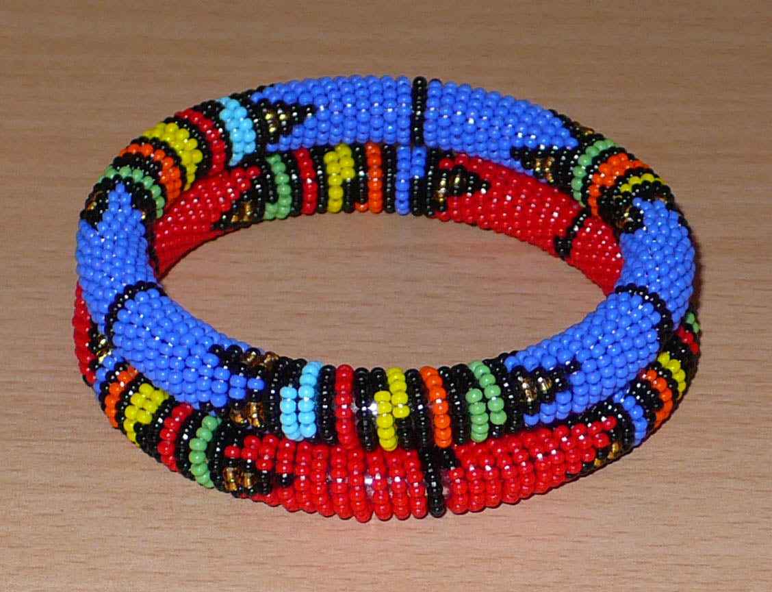 Lot de deux bracelets tubulaires à motifs ethniques de tradition sud-africaine zouloue, composés de perles de rocaille bleues pour l'un et rouges pour l'autre, et de perles multicolores.