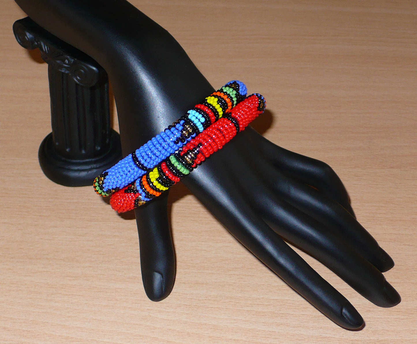 Lot de deux bracelets tubulaires à motifs ethniques de tradition sud-africaine zouloue, composés de perles de rocaille bleues pour l'un et rouges pour l'autre, et de perles multicolores.