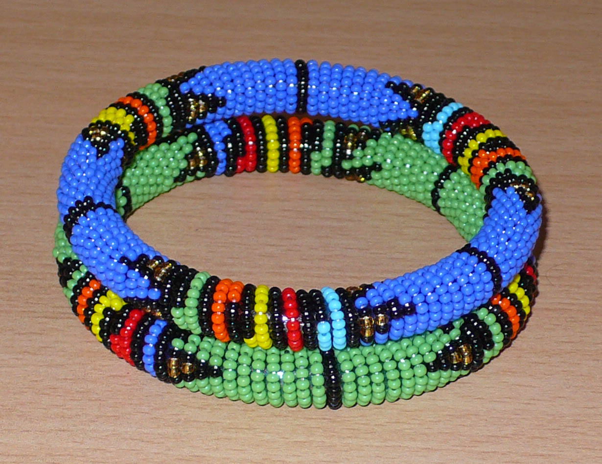 Lot de deux bracelets tubulaires de tradition sud-africaine zouloue, composés de perles de rocaille bleues pour l'un et vertes pour l'autre, et de perles multicolores pour les motifs.