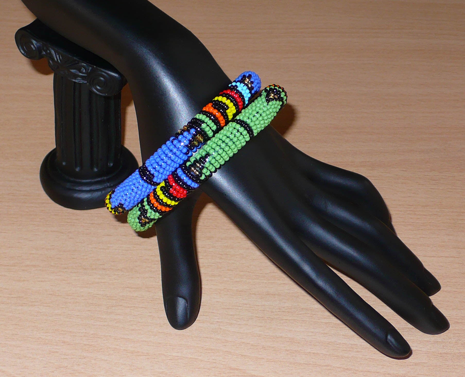 Lot de deux bracelets tubulaires de tradition sud-africaine zouloue, composés de perles de rocaille bleues pour l'un et vertes pour l'autre, et de perles multicolores pour les motifs.
