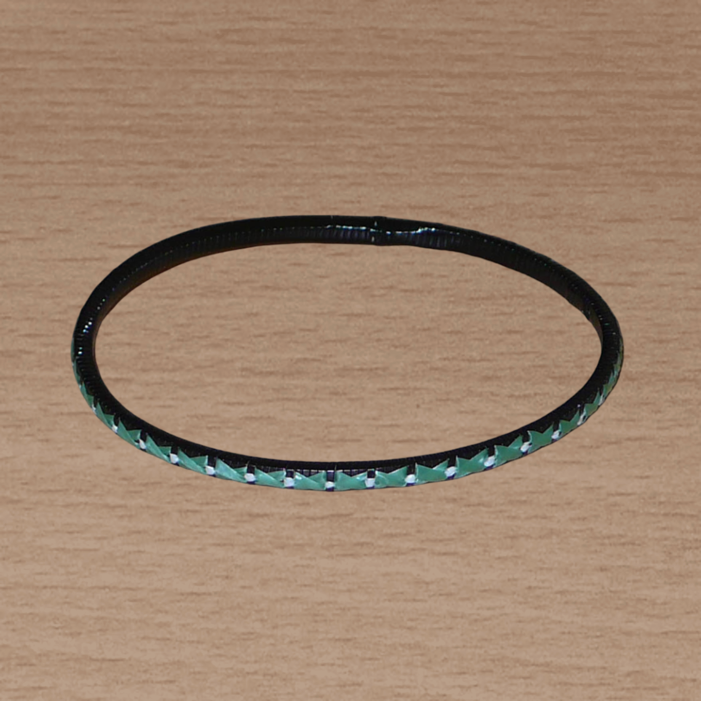 Lot de douze bracelets ethniques fabriqués au Mali dans une perspective eco-responsable, avec de fines bandes de plastique recyclé vert khaki, noir et blanc.