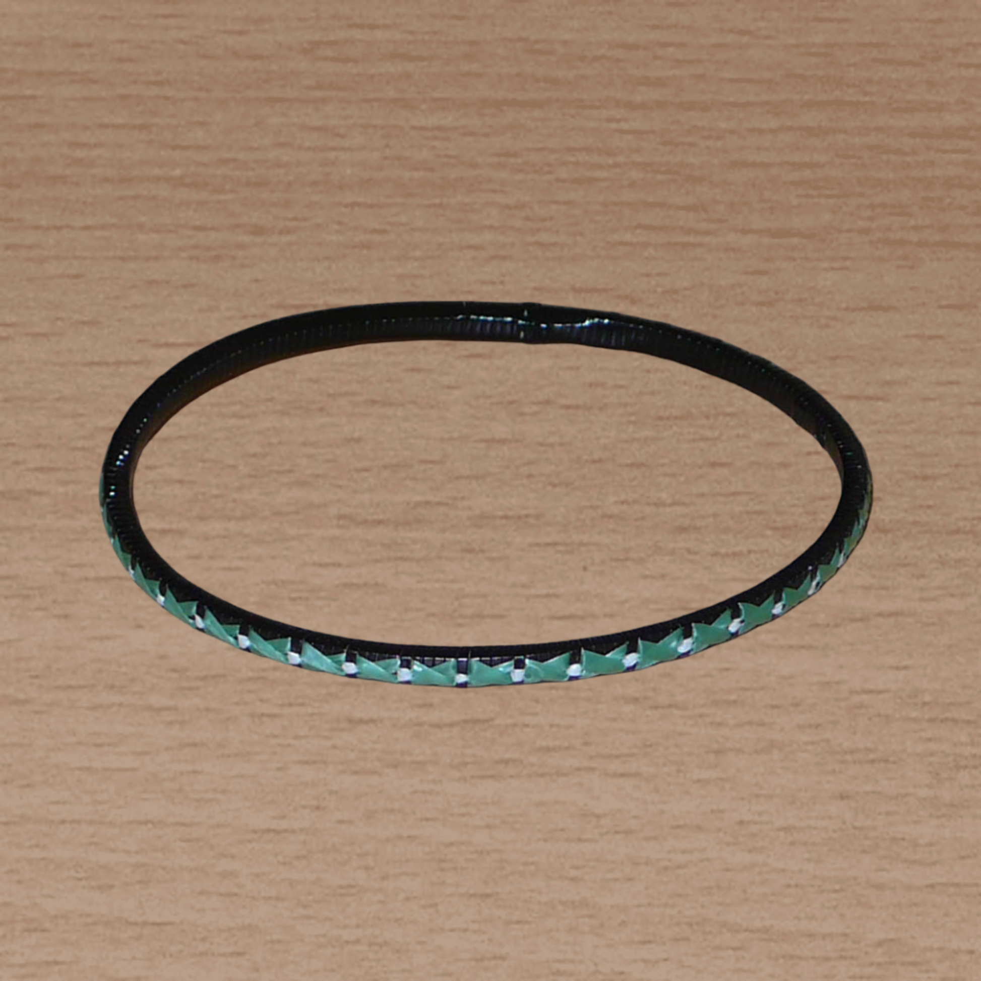 Lot de douze bracelets ethniques fabriqués au Mali dans une perspective eco-responsable, avec de fines bandes de plastique recyclé vert khaki, noir et blanc.