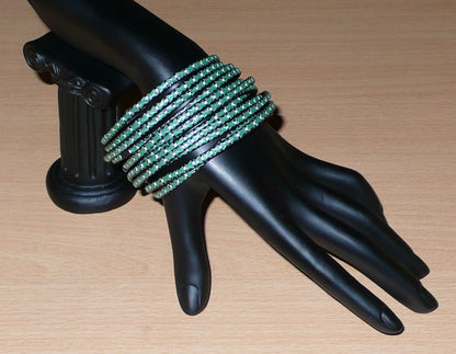 Lot de douze bracelets ethniques fabriqués au Mali dans une perspective eco-responsable, avec de fines bandes de plastique recyclé vert khaki, noir et blanc.