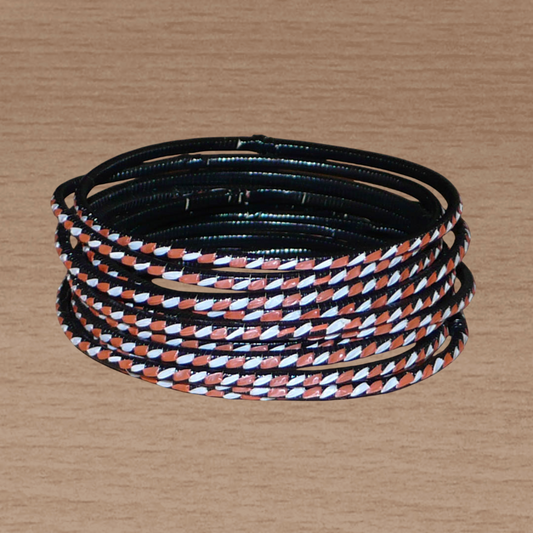Ensemble de 12 bracelets africains tricolores fabriqués dans une approche d'upcycling de matériaux de récupération : très fins et légers à porter, ils sont composés de plastique recyclé orange, blanc et noir tressés sur du carton.