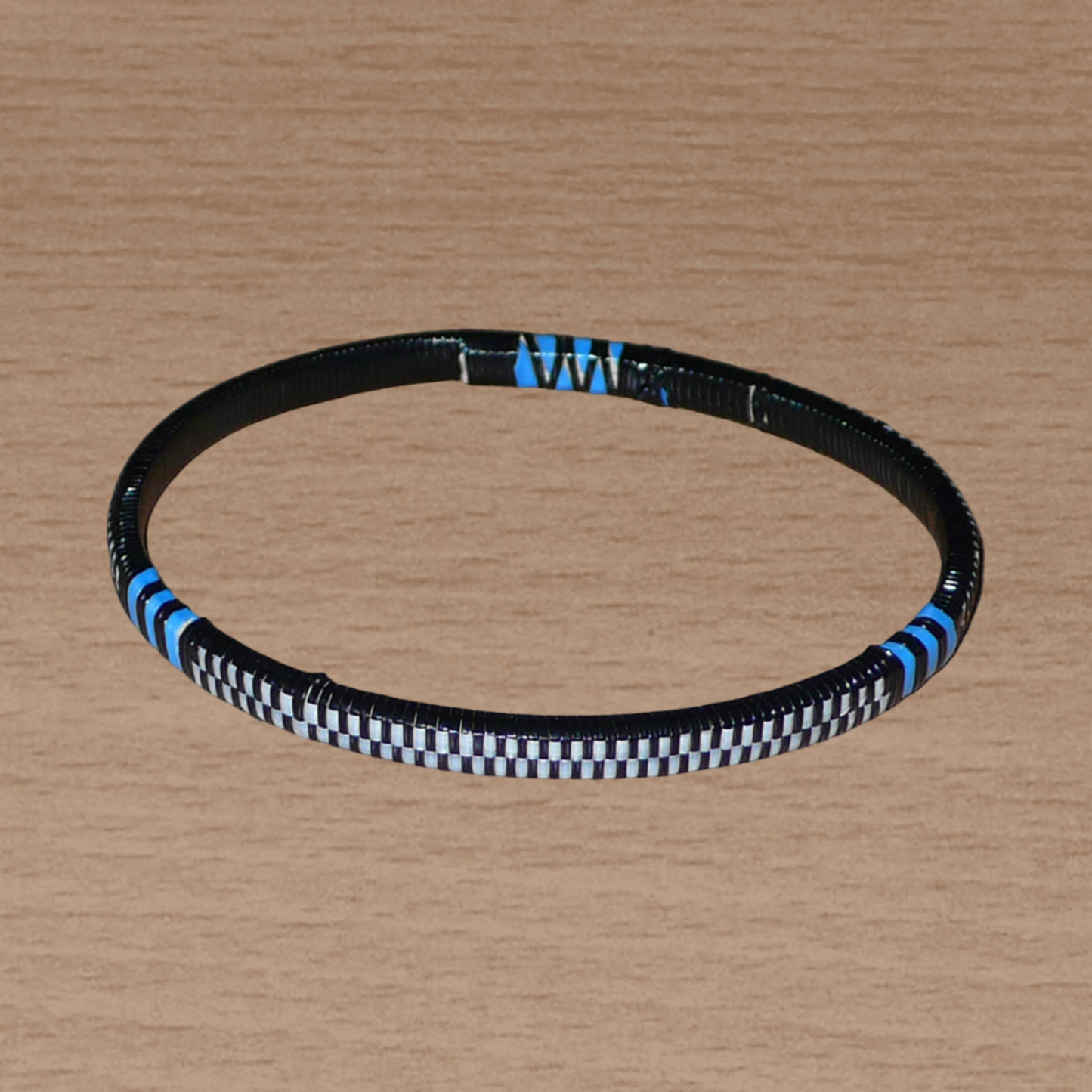 Ensemble de 12 bracelets africains tricolores fabriqués au Mali dans une optique éco-responsable avec de très fines bandes de plastique recyclé noir, bleu et blanc.