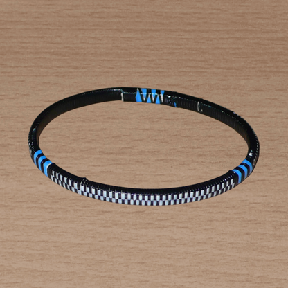 Ensemble de 12 bracelets africains tricolores fabriqués au Mali dans une optique éco-responsable avec de très fines bandes de plastique recyclé noir, bleu et blanc.