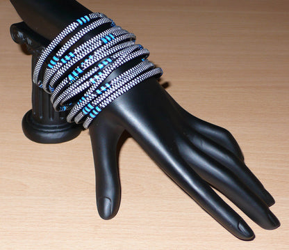Ensemble de 12 bracelets africains tricolores fabriqués au Mali dans une optique éco-responsable avec de très fines bandes de plastique recyclé noir, bleu et blanc.