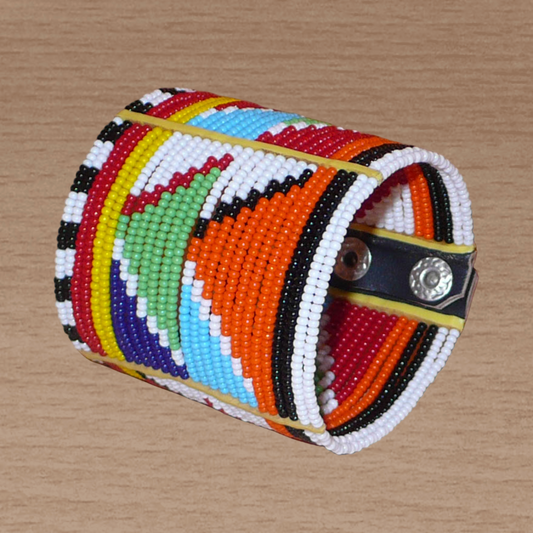 Bracelet africain Massai composé de vingt-six rangées de perles multicolores aux motifs géométriques enfilées sur des fils de fer fixés sur des charnières en plastique. Le bracelet se ferme avec des boutons pressions.