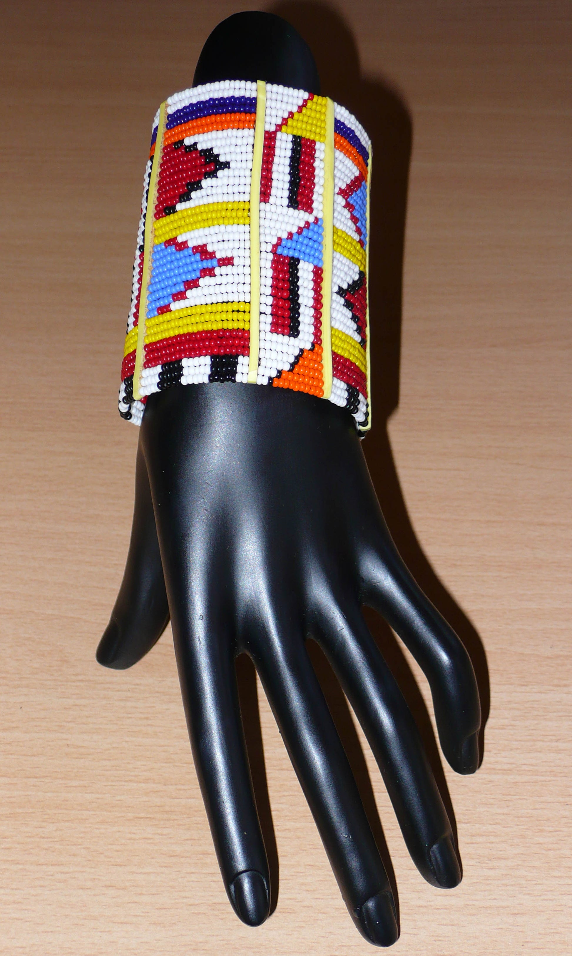 Bracelet africain multi-rangs à motifs ethniques Massai composé de trente-six rangées de perles de rocaille blanches et multicolores.