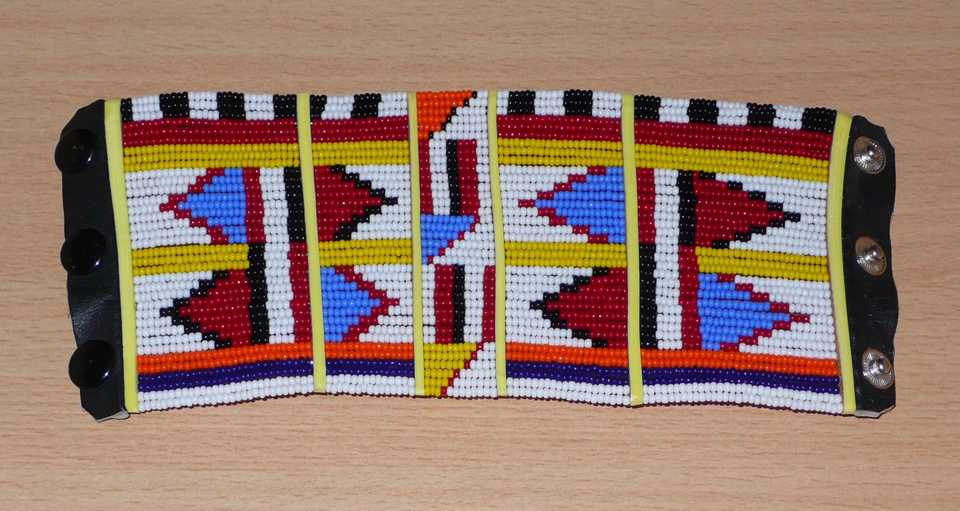 Bracelet africain multi-rangs à motifs ethniques Massai composé de trente-six rangées de perles de rocaille blanches et multicolores.