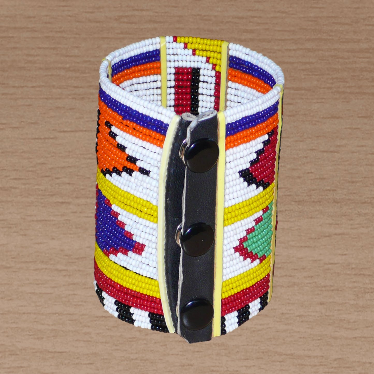 Manchette africaine perlée à motifs ethniques Massai composée de plusieurs rangs de perles de rocaille multicolores glissées sur des fils de fer fixés sur des charnières en plastique.