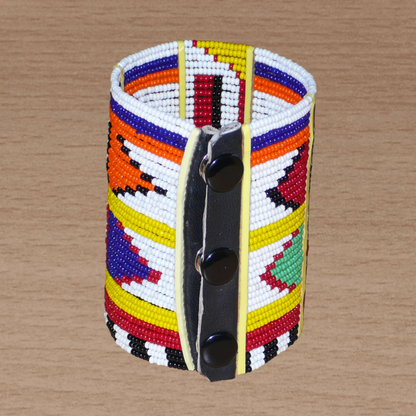 Manchette africaine perlée à motifs ethniques Massai composée de plusieurs rangs de perles de rocaille multicolores glissées sur des fils de fer fixés sur des charnières en plastique.